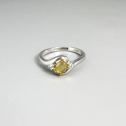 Opal solitaire ring in white gold plated sterling silver, featuring a natural gemstone with yellow hues, elegant and timeless design.