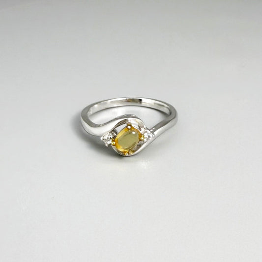 Opal solitaire ring in white gold plated sterling silver, featuring a natural gemstone with yellow hues, elegant and timeless design.