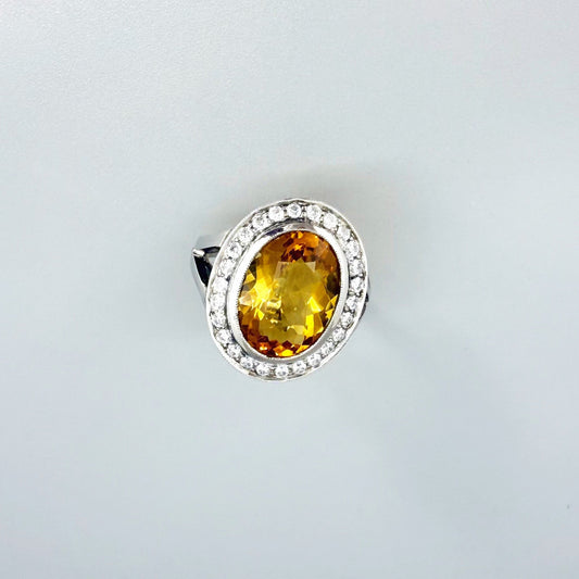 Citrine and CZ ring in white gold plated sterling silver, featuring a faceted golden-yellow gemstone surrounded by clear cubic zirconia halo, elegant and bright design.