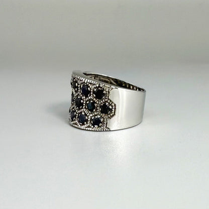 Wide band blue sapphire ring in white gold plated sterling silver featuring faceted deep blue sapphires for an elegant, timeless look.