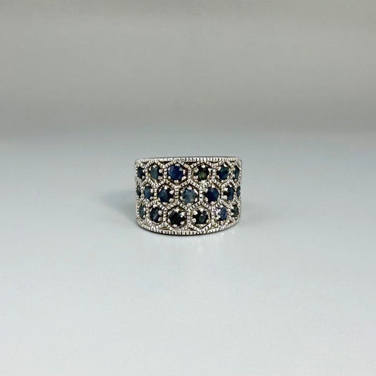 Wide band ring with light blue sapphires set in white gold plated sterling silver, reflecting soft blue brilliance with timeless elegance.