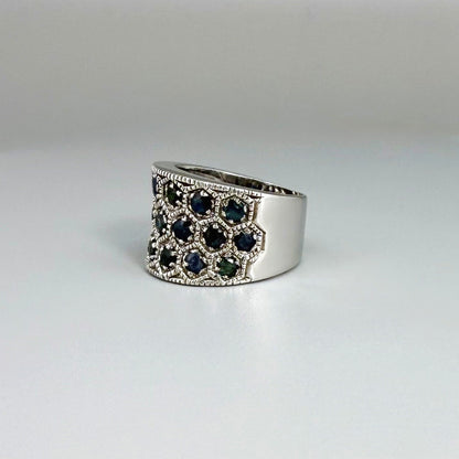 Wide band ring with light blue sapphires set in white gold plated sterling silver, reflecting soft blue brilliance with timeless elegance.