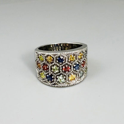 Multicolor sapphire band ring in white gold plated sterling silver, featuring faceted blue, yellow, pink, green, and orange gemstones, elegant wide design.