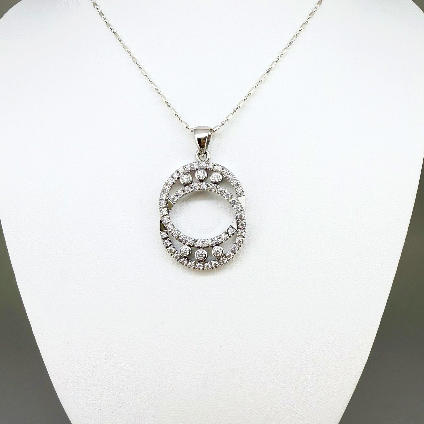 Handcrafted round pendant with cubic zirconia set in white-gold-plated sterling silver.