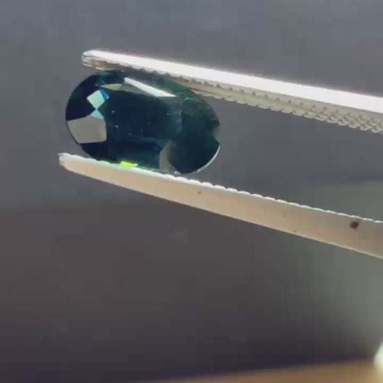 Natural heated deep teal Laos sapphire, 3.18 ct oval with eye-clean clarity and vivid blue-green flashes.