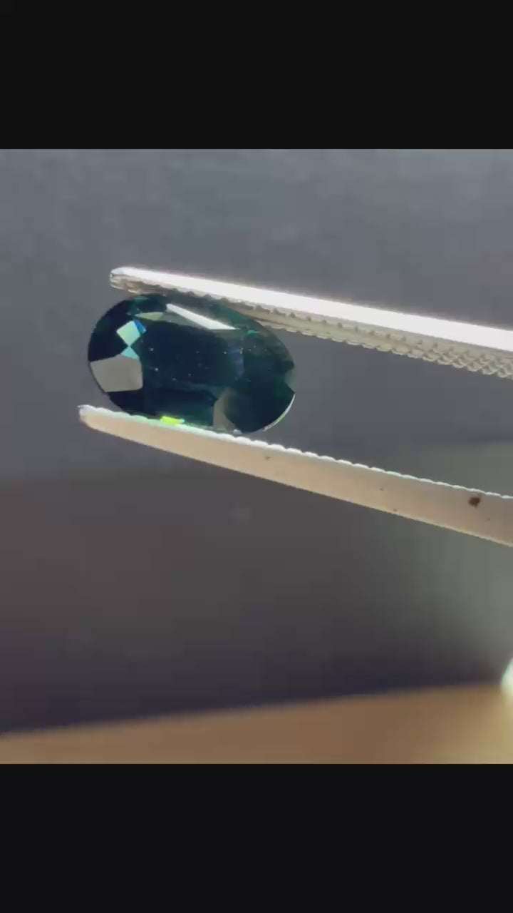 Natural heated deep teal Laos sapphire, 3.18 ct oval with eye-clean clarity and vivid blue-green flashes.