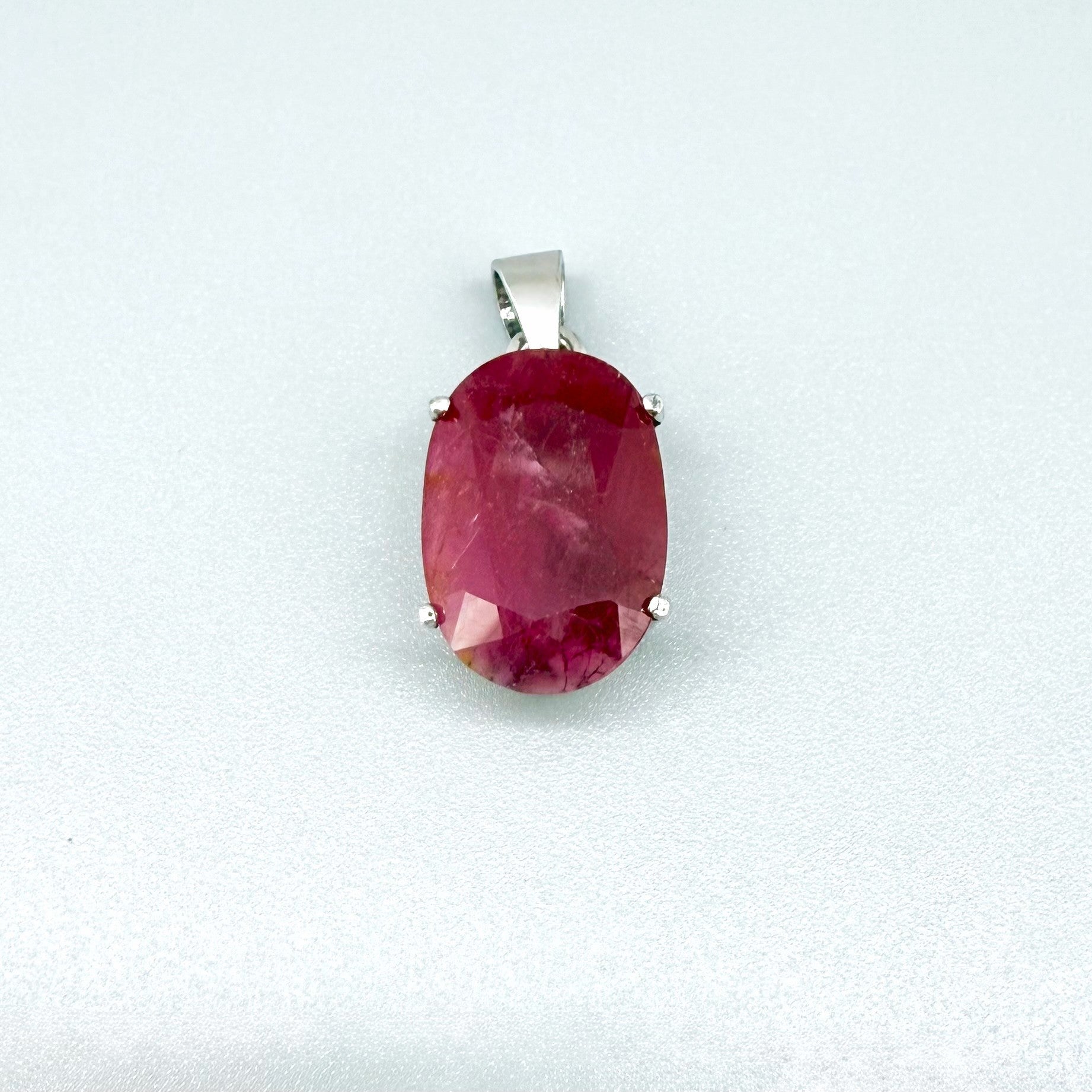 White gold plated silver pendant featuring a 17.12 ct natural ruby with deep red brilliance, handcrafted and elegant design.
